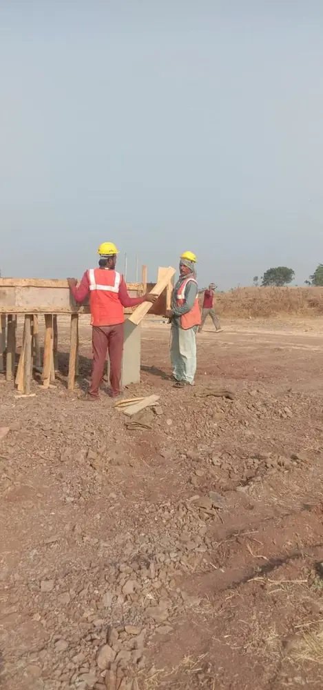 Crew in hard hats and high-visibility vests setting up timber formwork